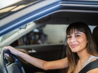 Mulher jovem dirige seu carro